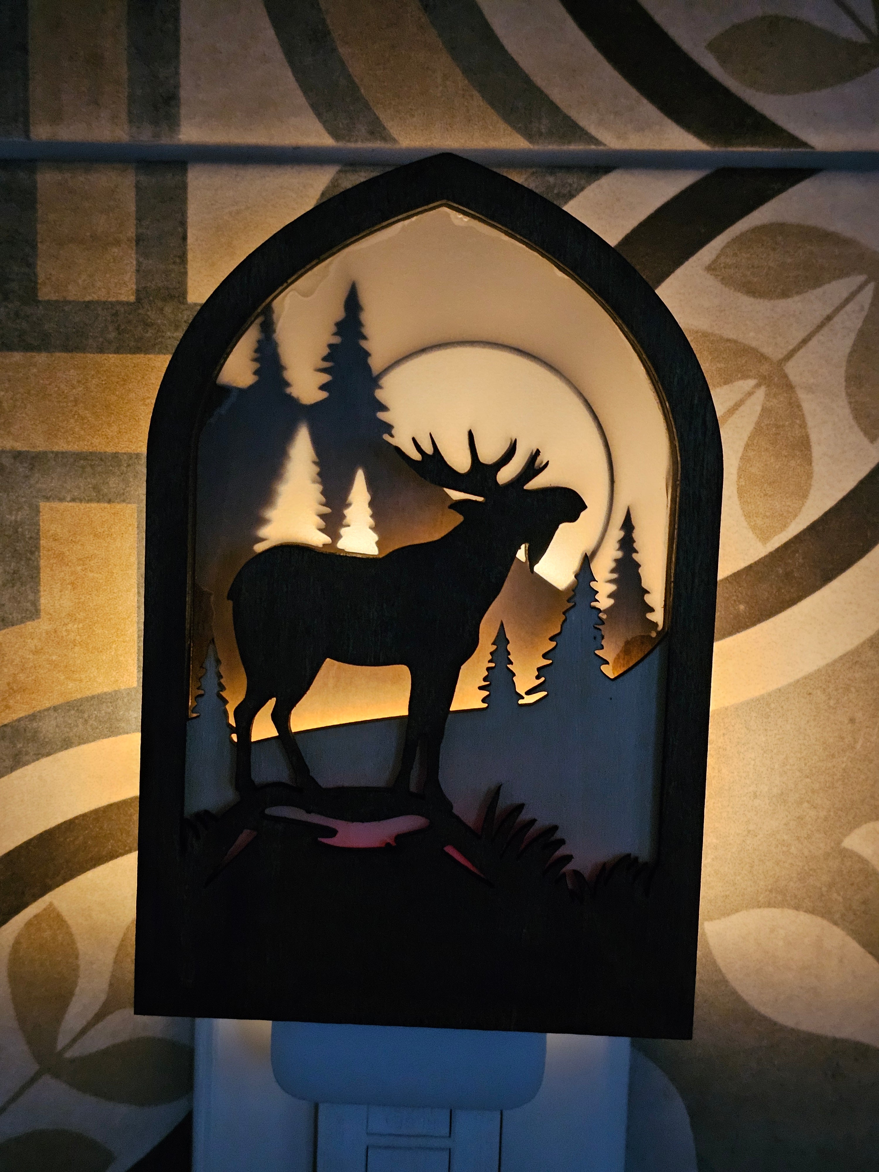 Rustic Moose Night Light glowing in a dark room