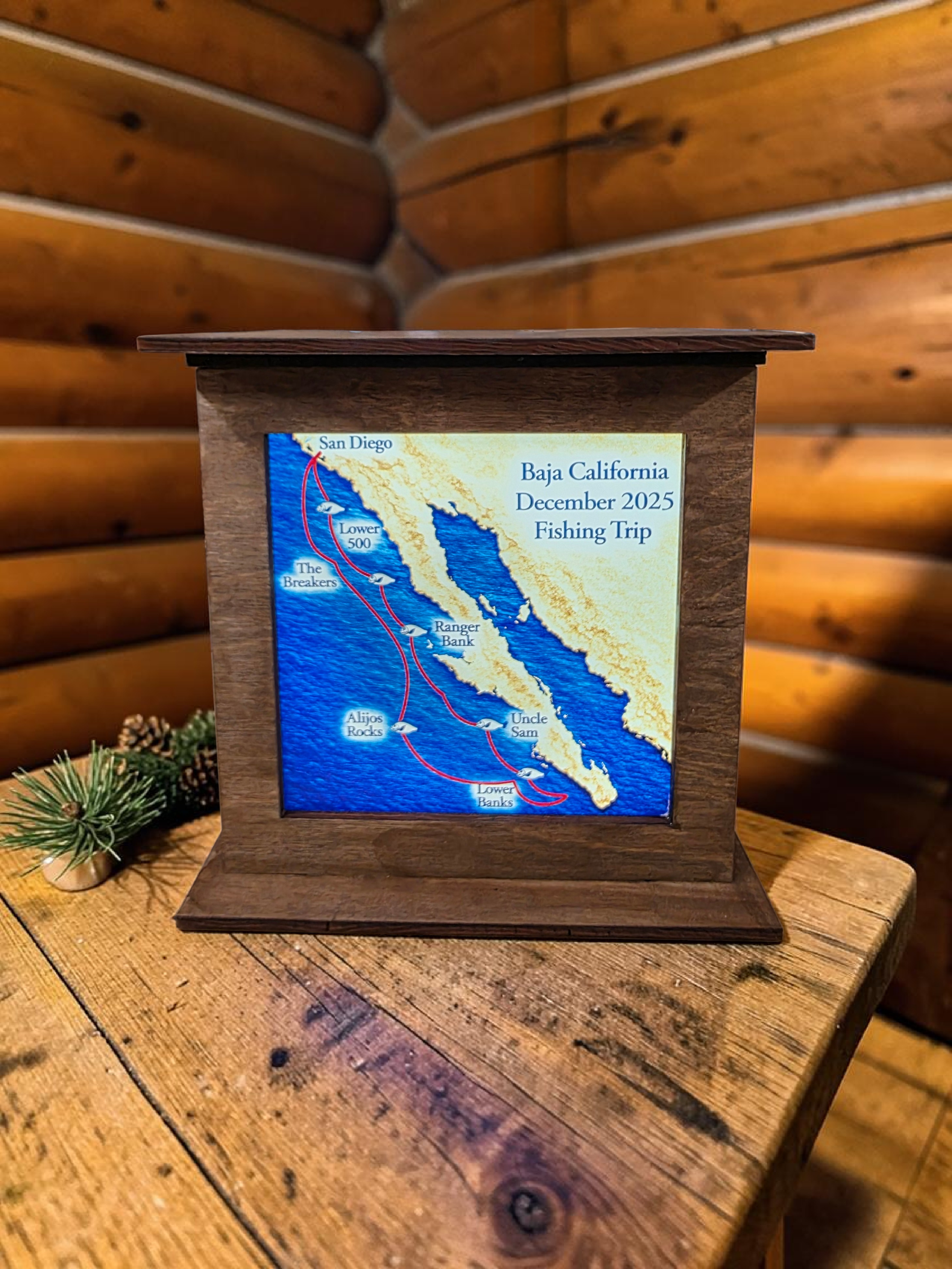 Small screen displaying a map of Baja California with a wooden frame on a wooden surface.