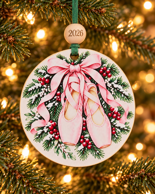 Ballet slippers Christmas ornament with pink pointe shoes on a snowy pine wreath, 4 inch round wood Christmas ornament with 2026 bead by Bandit Laser