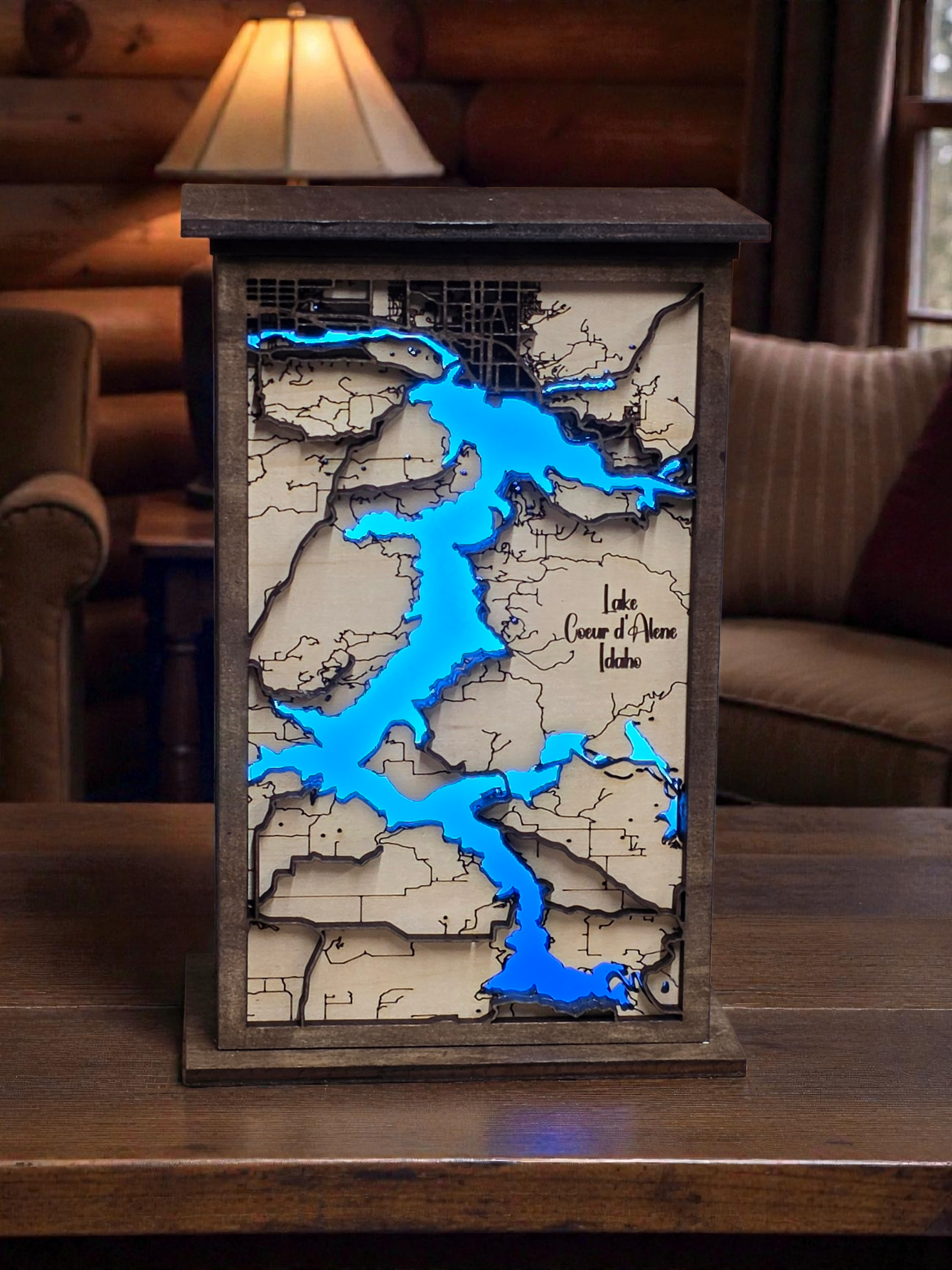 Wooden lamp with road map design and blue LED lights on a wooden surface.