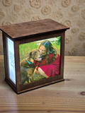 Wooden photo frame with a picture of a woman and dog on a wooden surface.