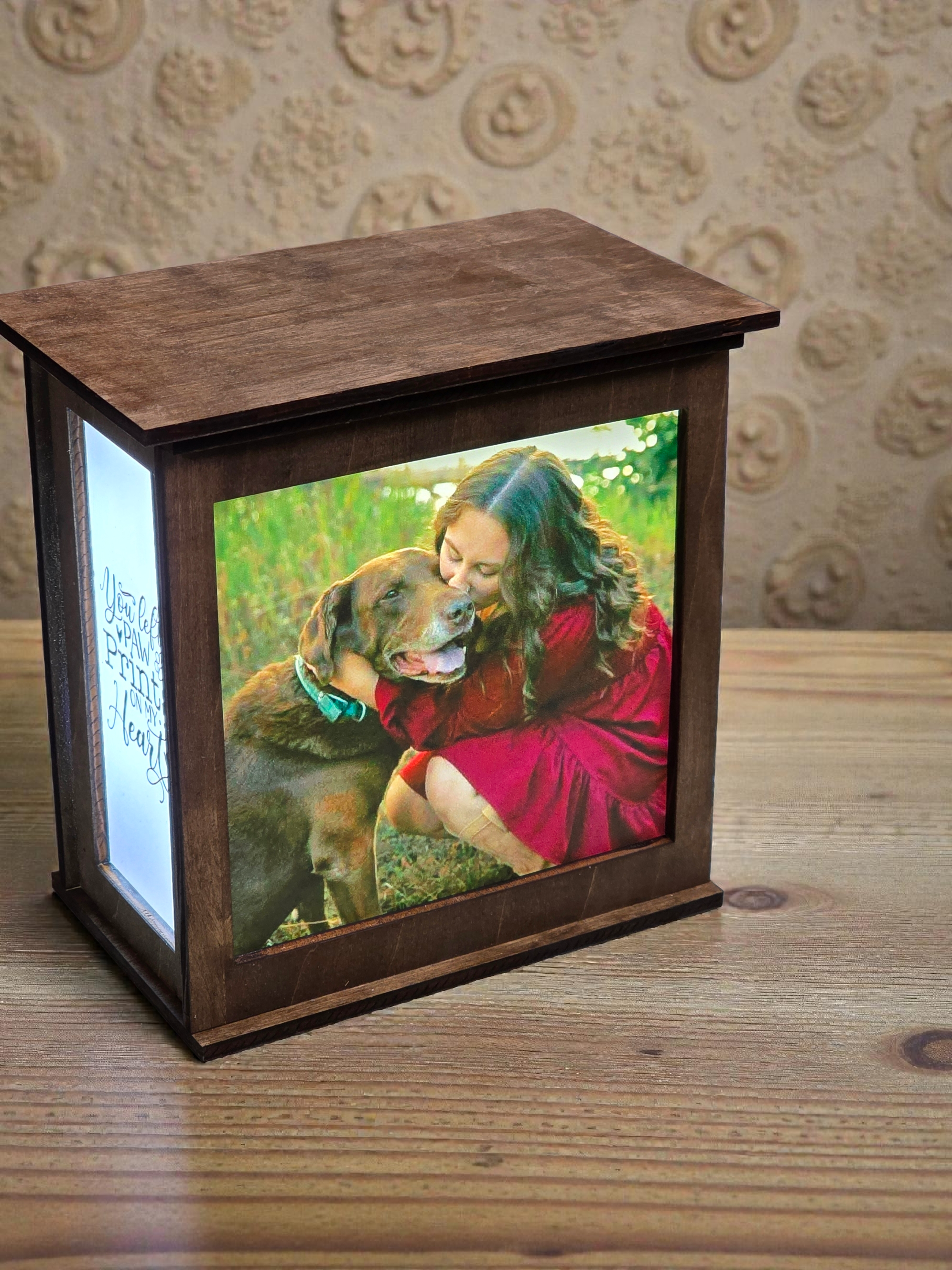 Wooden photo frame with a picture of a woman and dog on a wooden surface.