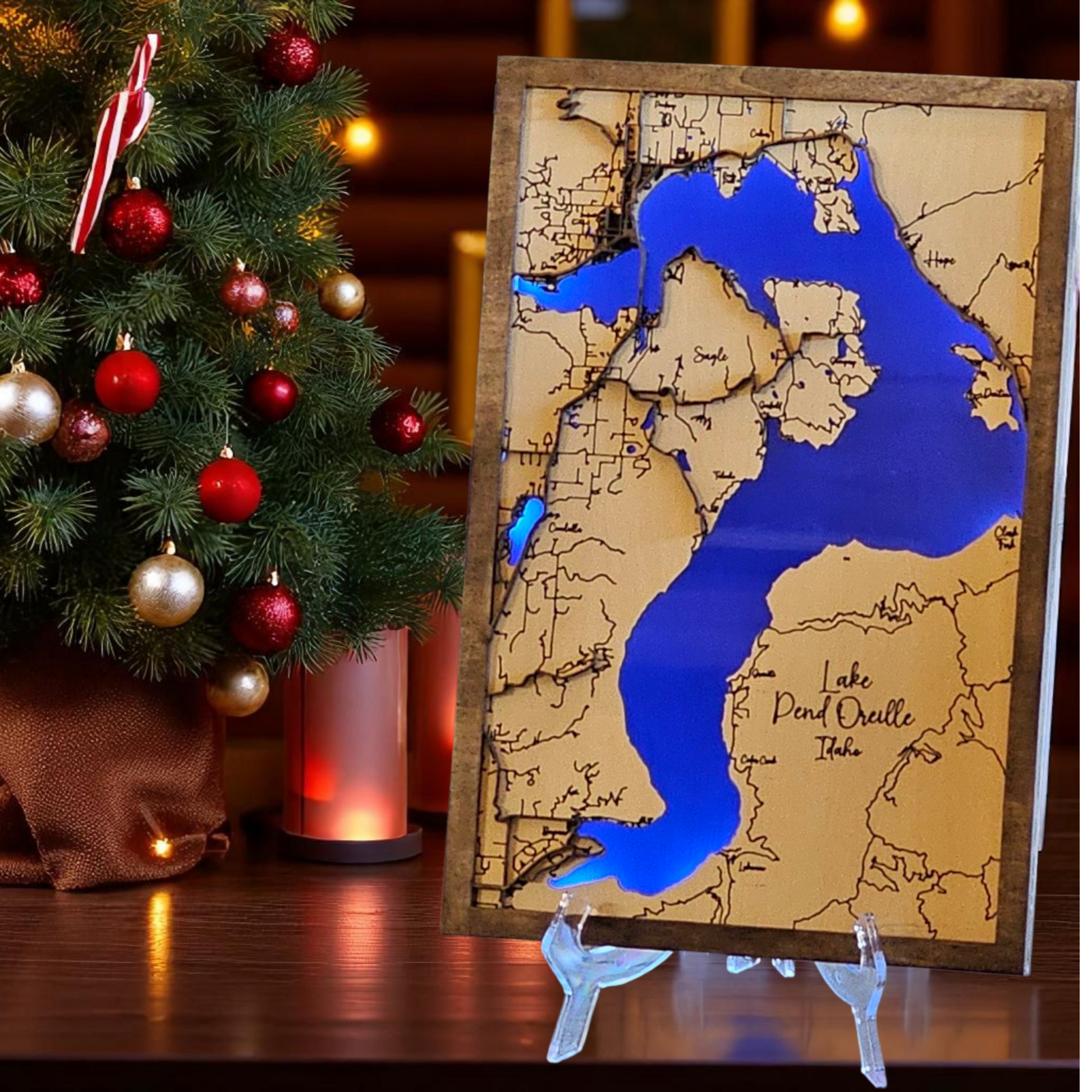 Wooden map of Lake Pend Oreille with Christmas tree in the background