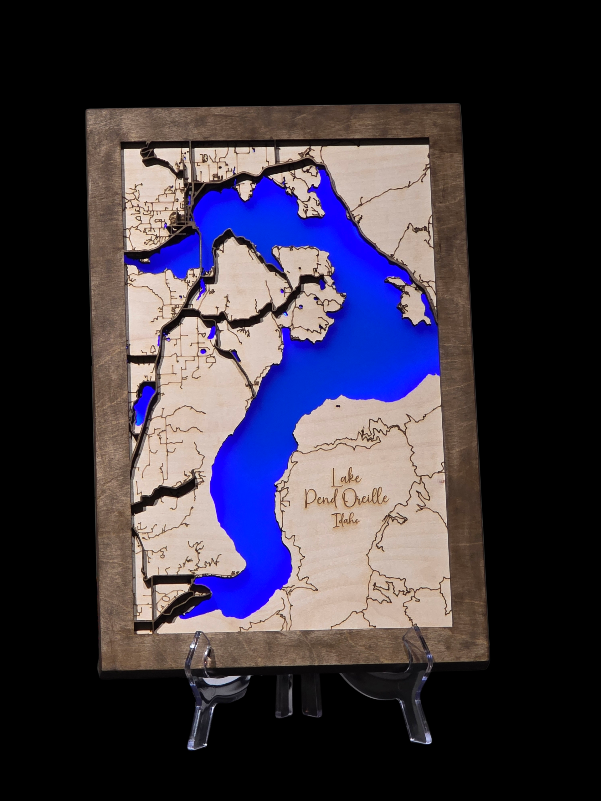 Wooden map of a lake with blue water and tan land, brown frame