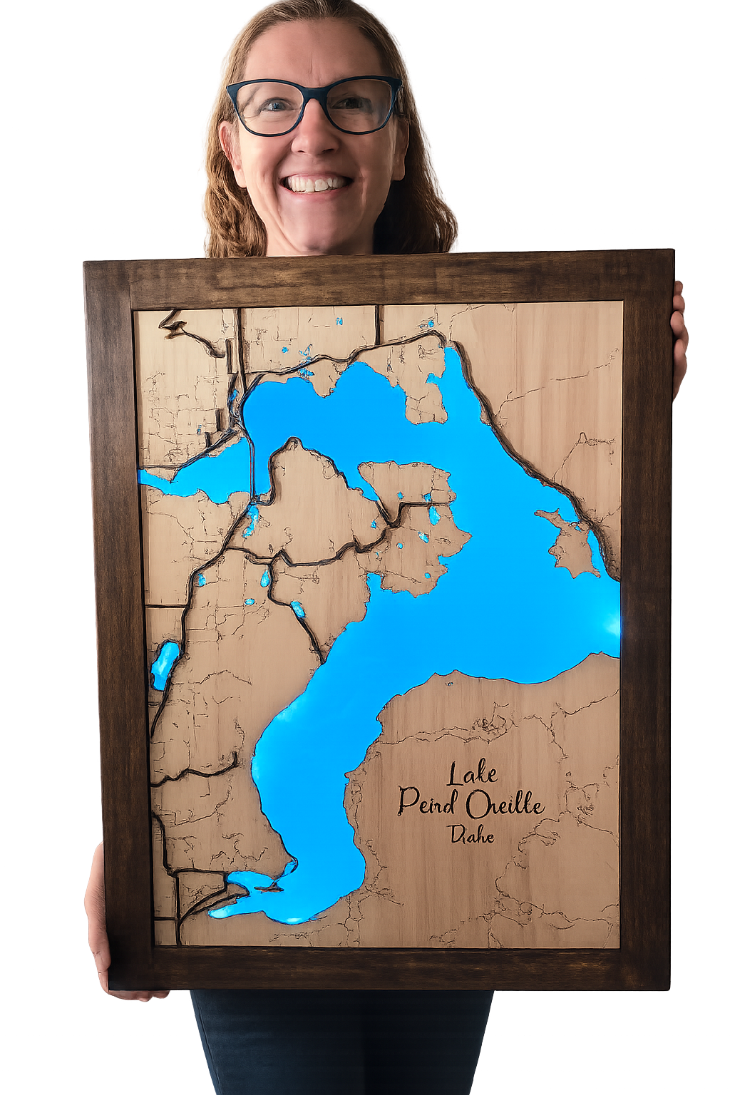 Person holding a framed wooden map of Lake Pend Oreille with blue water.