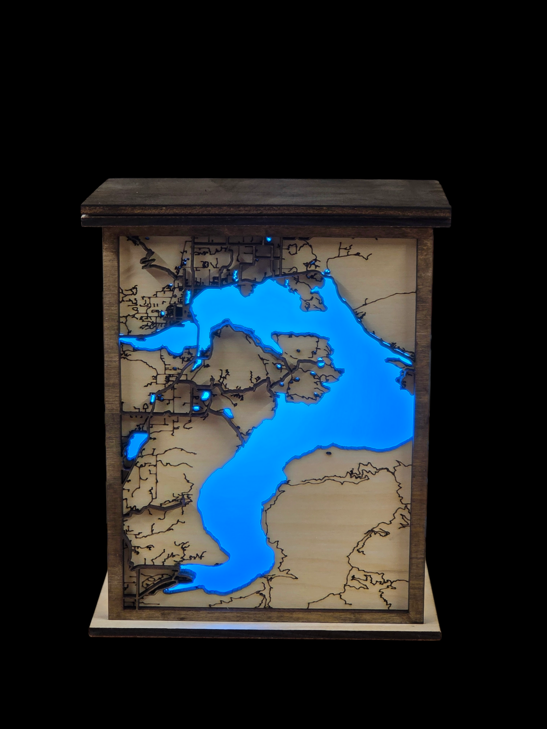 Wooden box with a map design illuminated by blue lights on a black background