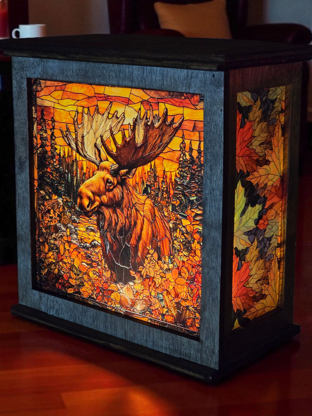 Decorative lamp with moose design and autumn leaves in a stained glass style.