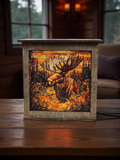 Decorative box with a moose design on a wooden surface