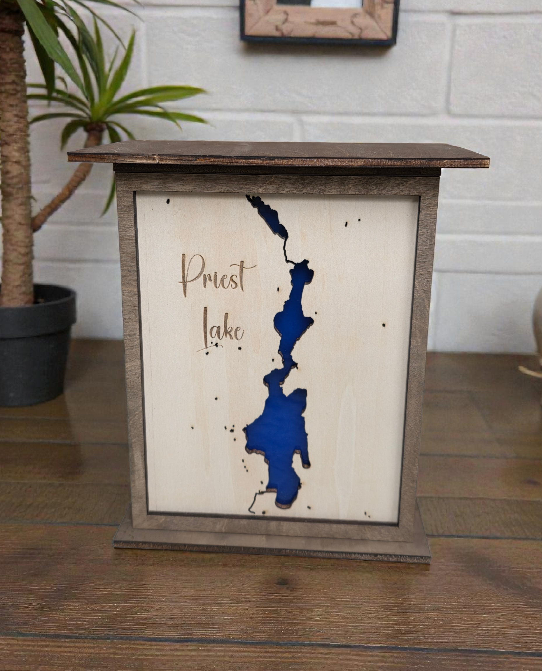 Wooden map of Priest Lake with a wooden frame on a table.