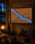 Lighted wooden Thompson Lakes Montana map glowing blue, hanging in a log cabin living room