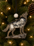 Layered wood wolf ornament with howling wolf, mountains, moon, and hidden woodland animals, hanging on a Christmas tree