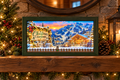 Lighted Christmas countdown with snowy mountain ski lodge, gondola, and snowman marker in a green frame on a mantel