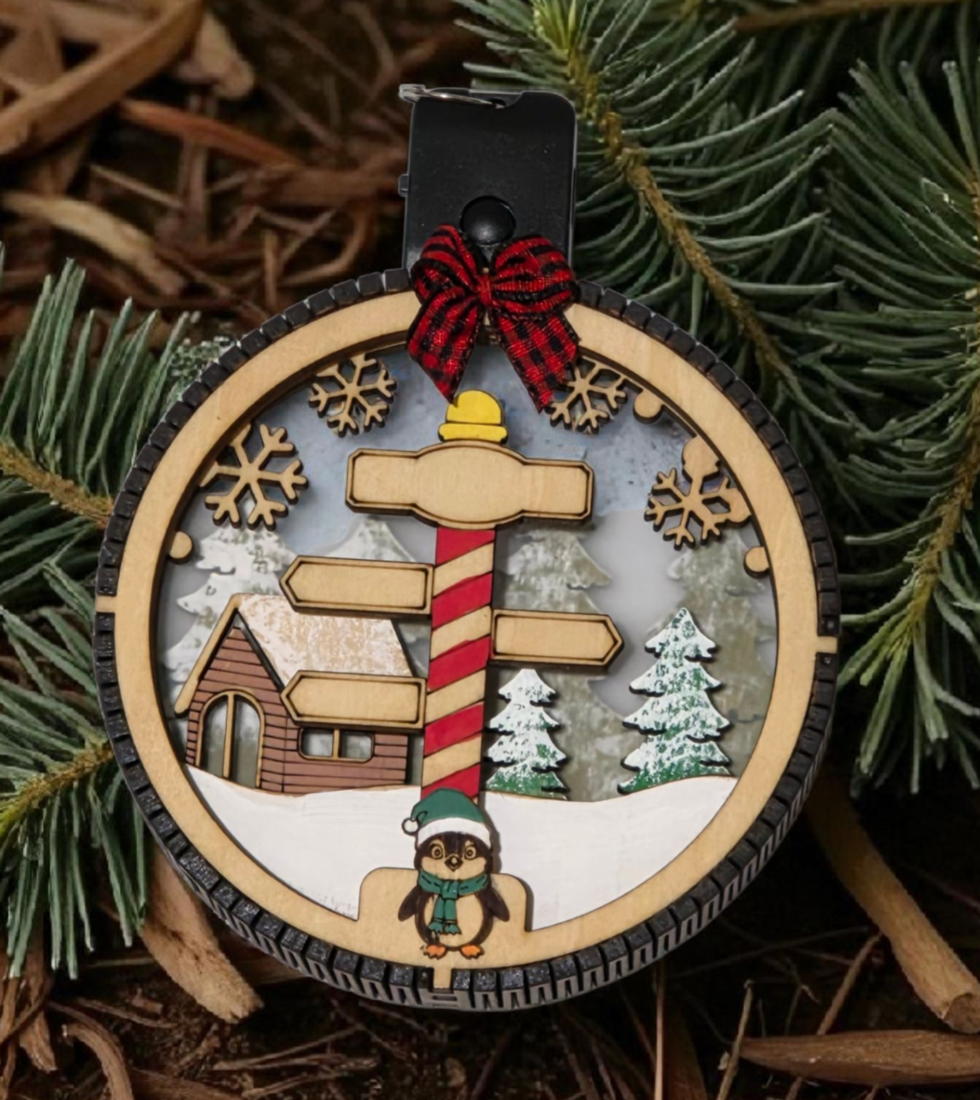 Personalized Lighted North Pole Ornament hanging on a tree
